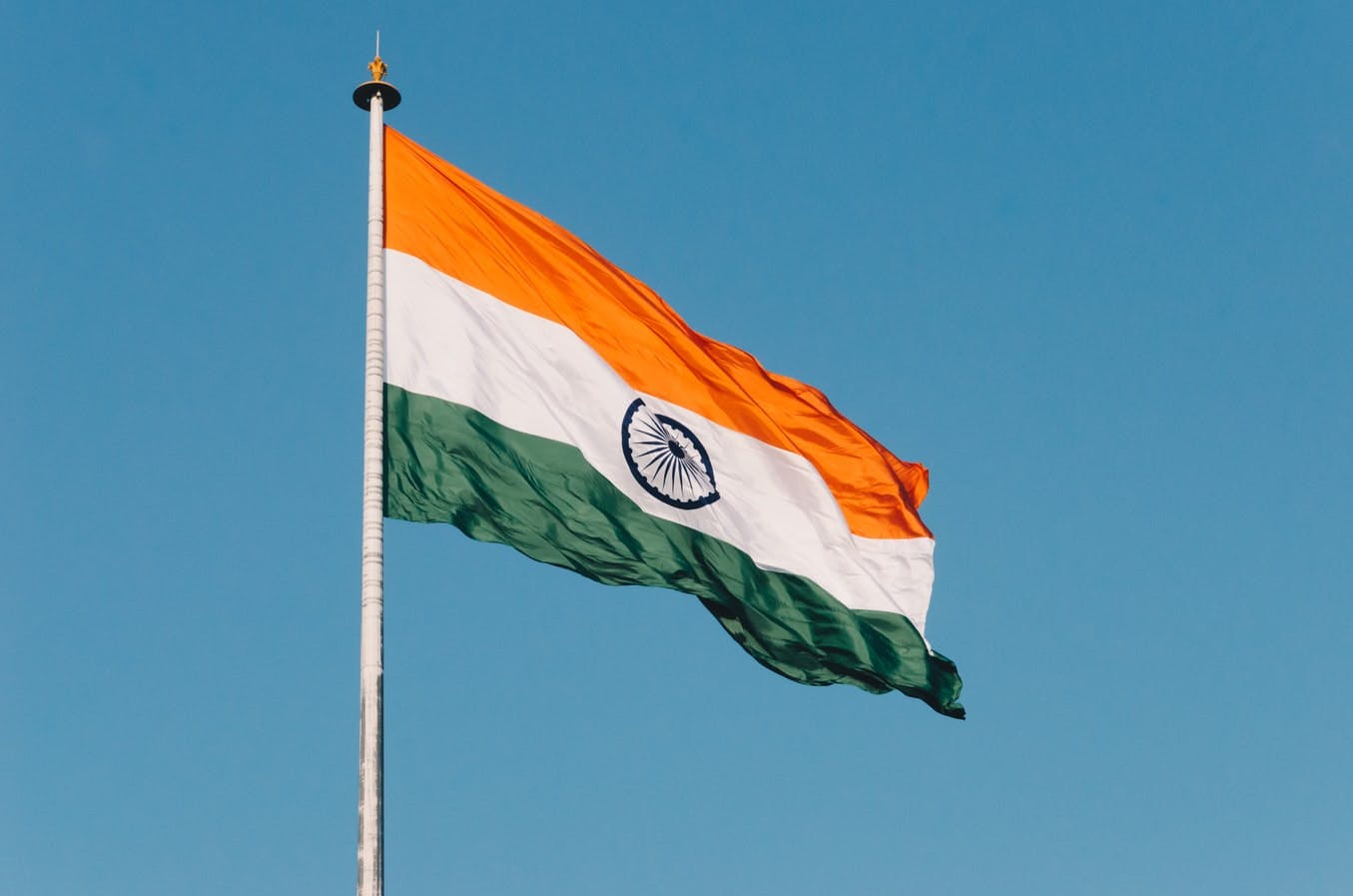 Indian flag waving against a blue sky